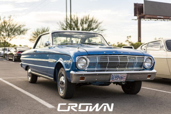 Restored blue 1963 Ford Falcon Sprint at a car show in Tucson, Arizona, front three-quarter view at dusk
