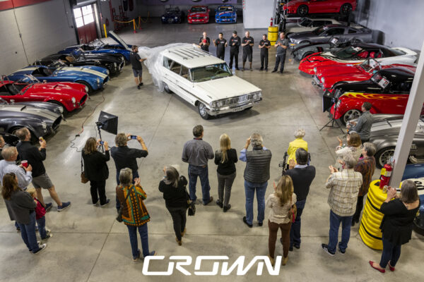 Crowd gathered for the reveal of a restored 1964 Ford Country Sedan wagon at Crown Customs