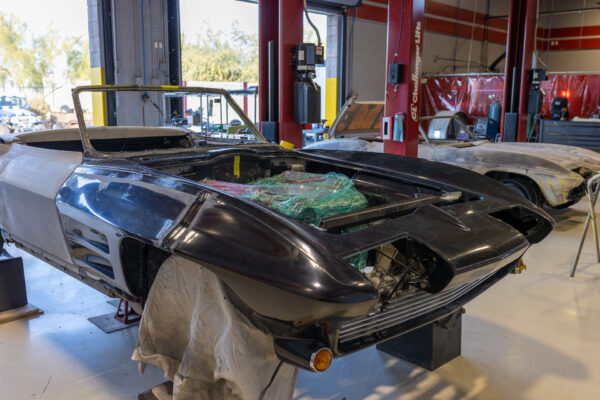 Gutted engine bay and front clip of a 1963 Corvette Sting Ray during restomod build