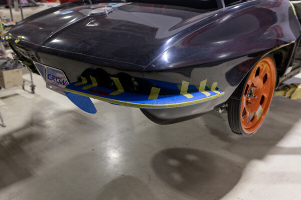 Rear tail section of a 1963 Corvette Sting Ray with masking tape and a Crown Customs dealer plate