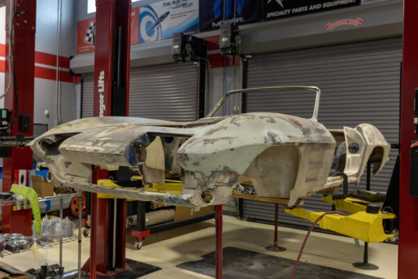 Primer-grey 1963 Corvette Sting Ray convertible body, front three-quarter view on stands