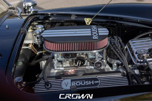 Front three-quarter view of a Superformance MKIII Cobra, chassis SP03627, solid black at Crown Customs in Tucson, Arizona