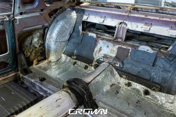 Interior floor pan of a 1966 Ford Thunderbird with sound deadening removed, revealing rust