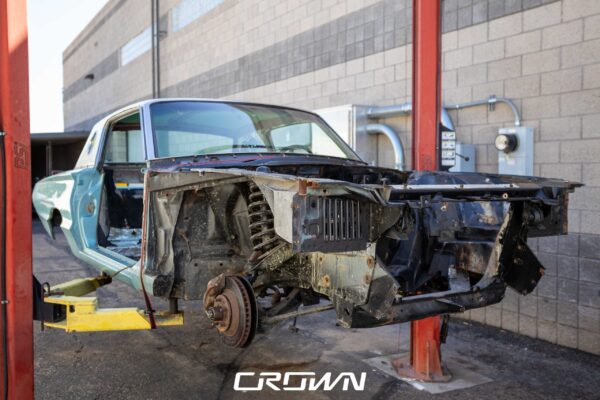 Disassembled front end of a 1966 Ford Thunderbird on a lift during teardown
