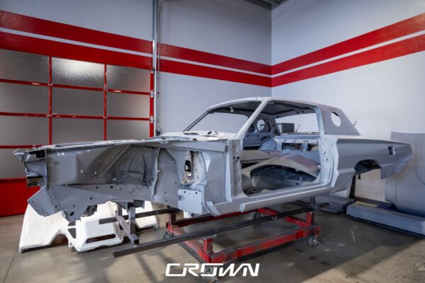 Three-quarter view of a 1966 Ford Thunderbird shell in bare primer during restoration