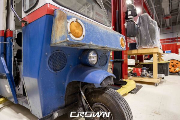 Front corner and headlight detail of a 1964 Rand Mailster postal vehicle at Crown Customs