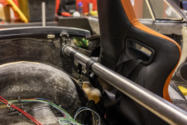 Custom orange racing seat with roll bar padding in a 1963 Corvette Sting Ray restomod