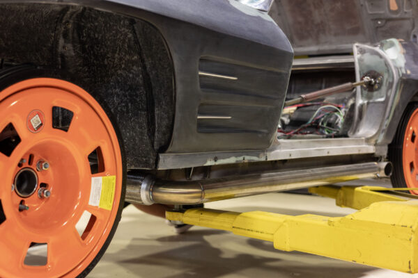 Wide-body fender flare and rocker panel detail on a 1963 Corvette Sting Ray, orange wheel