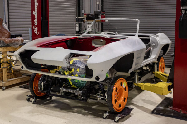 1963 Corvette Sting Ray body panels in red and white two-tone primer on stands