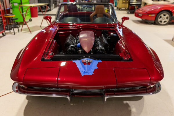 Rear engine lid open on a finished 1963 Corvette Sting Ray, LS engine under a smoked cover