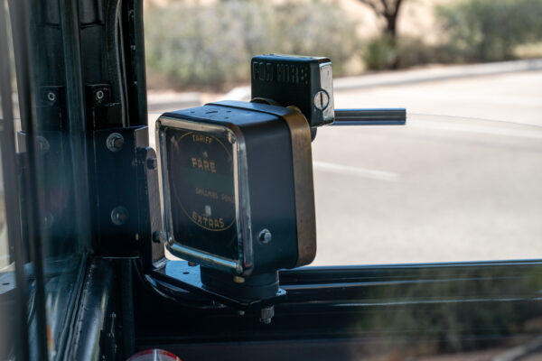 Original chrome fare meter mounted at the drivers partition inside the Austin FX4 London taxi cab