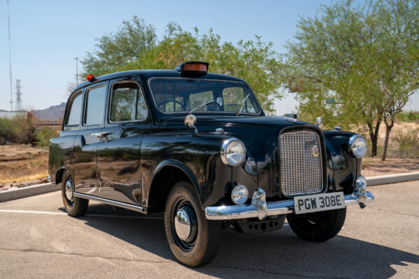 Finished 1967 Austin FX4 London taxi cab in black, front three-quarter view outdoors in the Arizona desert after its Crown Customs build