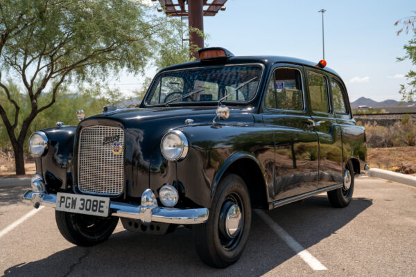 Black Austin FX4 London taxi photographed from the front three-quarter angle, showing its upright grille and rear passenger doors