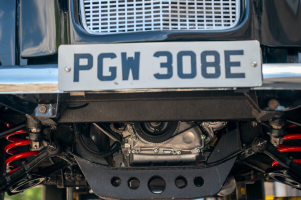 Front underside of the Austin FX4 London taxi cab showing red coil springs, a fabricated skid plate and the original British registration plate