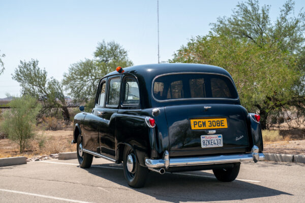 Rear three-quarter view of the Austin FX4 London taxi cab wearing both its original British registration plate and a current California plate