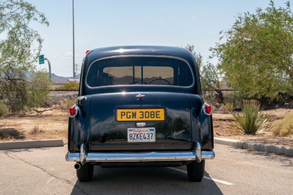 Rear view of the black Austin FX4 London taxi cab with its chrome bumper, round tail lights and upright cab roofline