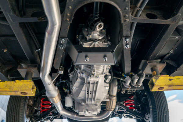Underside of the 1967 Austin FX4 London taxi cab on a lift, showing the automatic transmission, driveshaft and stainless exhaust