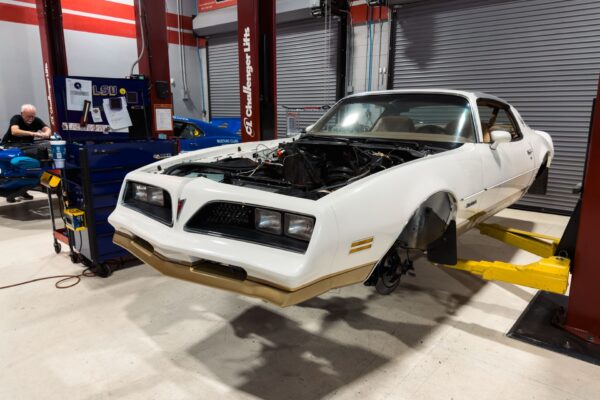 The 1978 Pontiac Firebird Formula on a lift in the Crown Customs shop in Tucson, Arizona, partway through its mechanical refurbishment