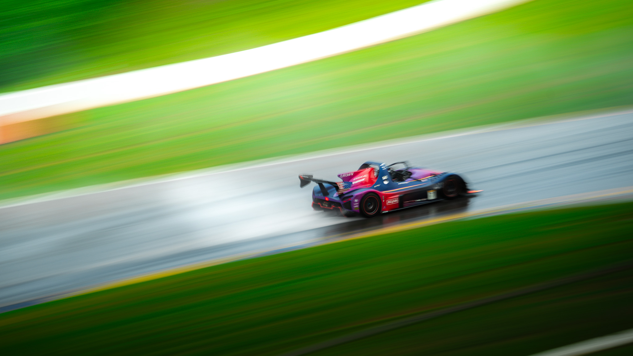 Josh Holtz driving the purple number 7 Crown Radical SR3 through heavy rain at Road Atlanta
