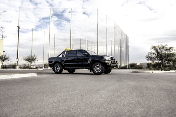 Black 2016 Toyota Tacoma built as a tribute to the truck from Back to the Future, side profile at dusk