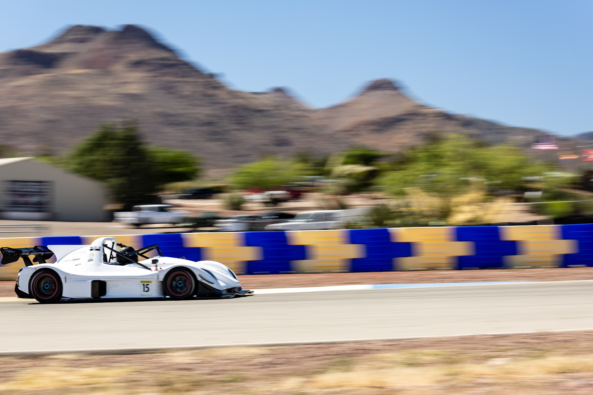 Radical SR3 XXR number 15 at speed through an Inde Motorsports Ranch corner during an IMRCS race