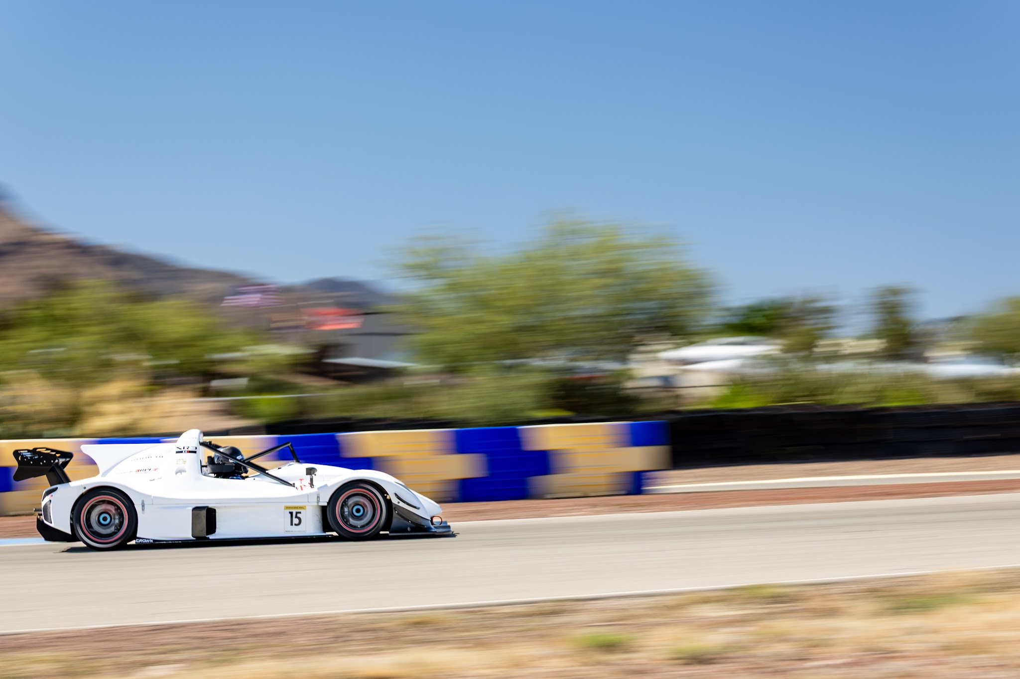 Ryan George's white number 15 Radical SR3 XXR at speed on track at Inde Motorsports Ranch in Arizona