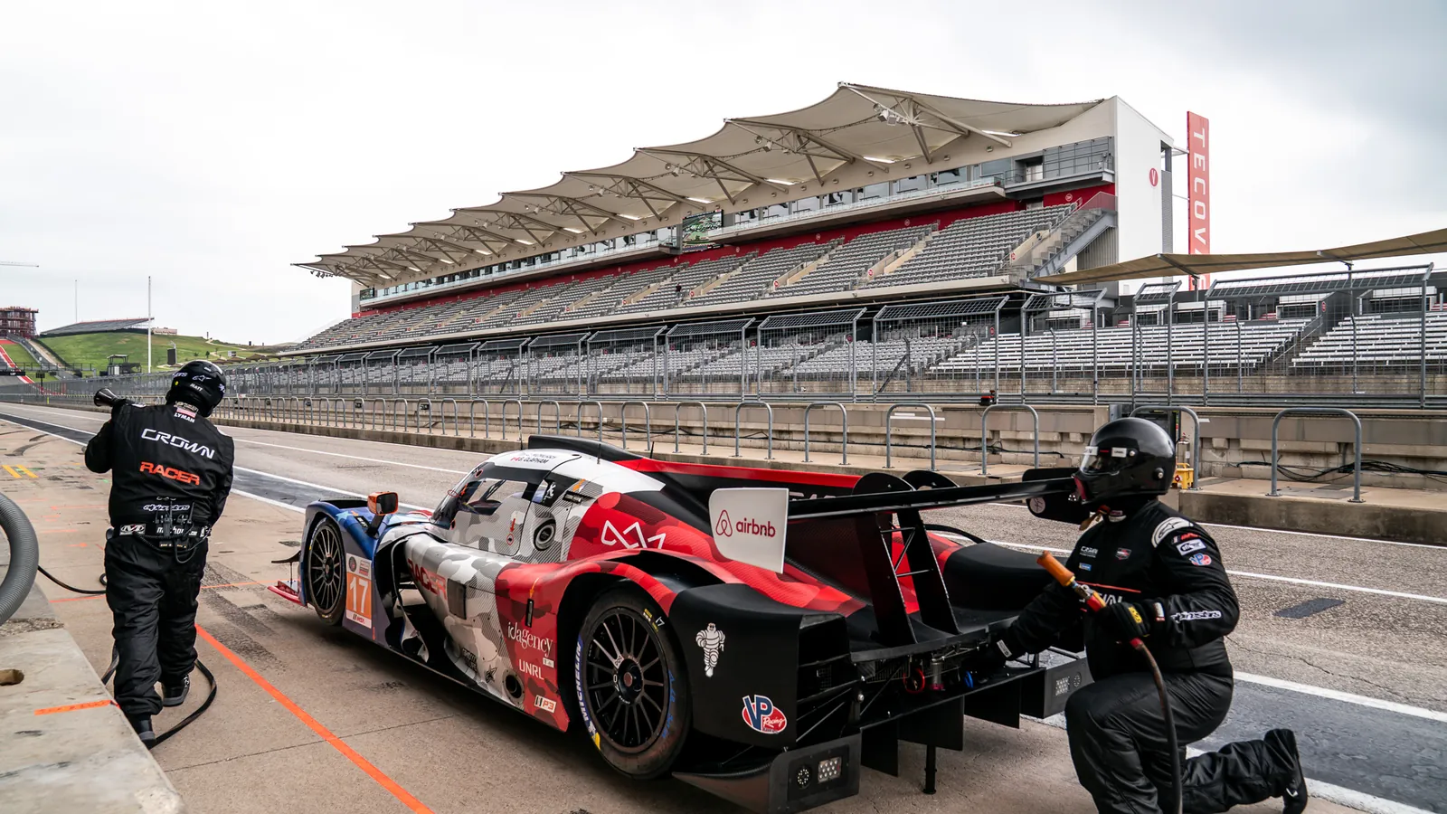 Crown Racing crew working the No. 17 Ligier JS P320 during a pit stop at Circuit of The Americas, the main grandstand behind